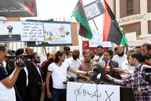 Member of the Supreme Council of Libyan Revolutionaries Adel al Ghiryani (R) adresses to journalists in front of the foreign ministry that has been surrounded by gunmen demanding it be "cleansed of agents" and ambassadors of ousted dictator Moamer Kadhafi on April 28, 2013 in the Libyan capital Tripoli. (AFP Photo)