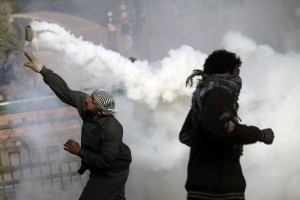 A protester throws back a tear gas canister during clashes with Egyptian riot Police on Tahrir Square on November 2012 (AFP FILE PHOTO / MAHMOUD KHALED)