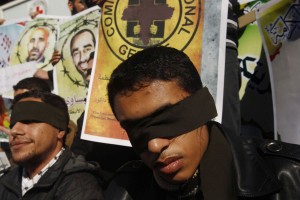 Palestinian men who covered their eyes with black ribbons demonstrate in support of Palestinian prisoners held in Israeli jails, some of whom are observing a hunger strike, in Gaza City on December 22, 2012. (AFP PHOTO/MOHAMMED ABED)
