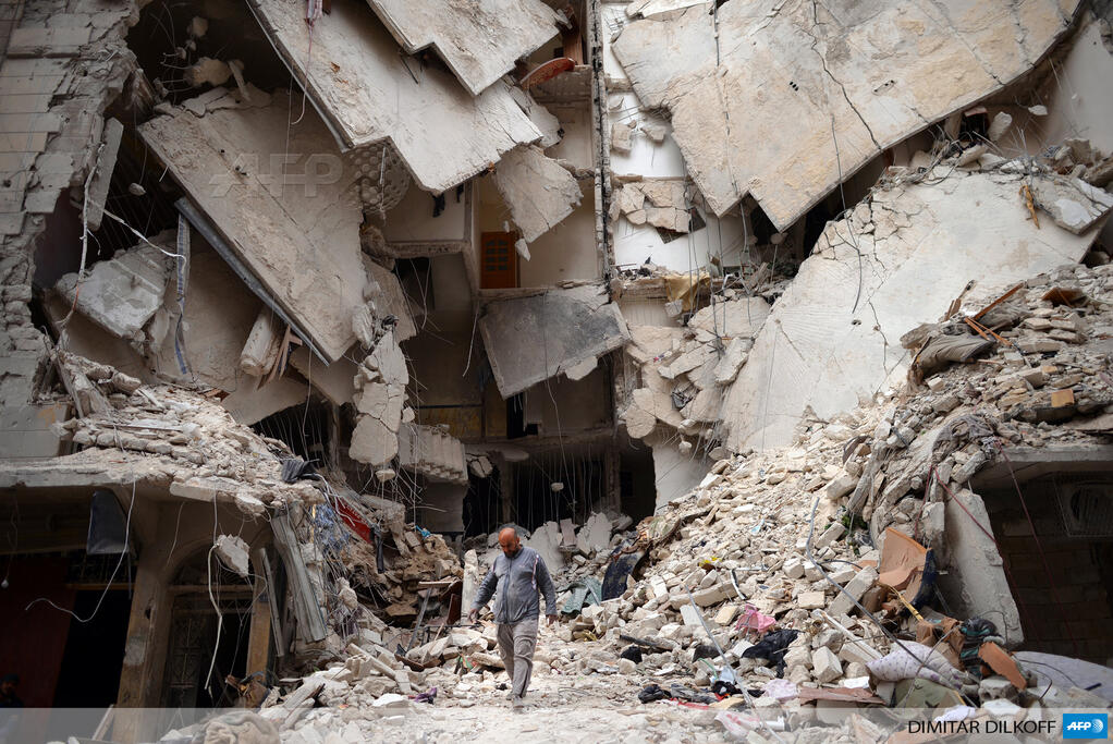 A man walks amid a ruined building in the northern Syrian city of Aleppo (AFP Photo)