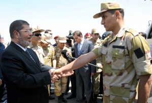 A handout picture released by the Egyptian Army shows Egyptian President Mohamed Morsi (L) greeting one of the soldiers who was seized in Sinai by kidnappers, at Almaza military Airbase in Cairo (AFP Photo)