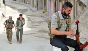 A Free Syrian Army soldier from a Kurdish brigade with a flower at the end of his AK-47 in Aleppo (AFP Photo/ File Photo) 
