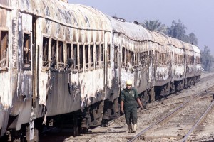An Egyptian rescuer walks next to a burned train near Ayyat, 75km (47 miles) south of Cairo in 2002  (Photo by : Amr Nabil) 