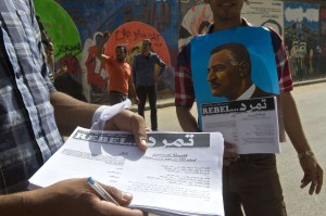 An Egyptian man distributes a sheet of Tamarod (rebellion) campaign try to collect signatures to demand the ouster of Egyptian President Mohamed Morsi and for early presidential elections in Cairo on May 17, 2013.  (AFP Photo)