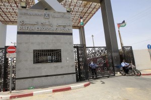 A member of the Palestinian Hamas security forces drives his motorcycle by the closed gate of the Rafah crossing with Egypt in the southern Gaza Strip on May 19, 2013. (AFP Photo)