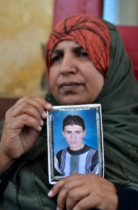 Amal al-Sayed, mother of Egyptian soldier Ahmed Abdelbadi who was kidnapped in the Sinai, holds her son's picture near the gate of the Rafah crossing border between Egypt and the Gaza Strip on May 20, 2013 during a demonstration calling for the release of Egyptian security forces kidnapped by gunmen. (AFP Photo)