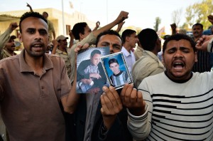 Egyptian protesters shout slogans while holding pictures of kidnapped soldiers Sayed Maslub (L) and Ahmed Abdelbadi (R) near the gate of the Rafah crossing border between Egypt and the Gaza Strip on May 20, 2013 during a demonstration calling for the release of Egyptian security forces kidnapped by gunmen.  (AFP Photo)