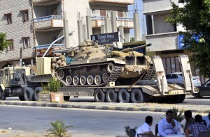 An Egyptian military truck carries a tank through the Sheikh Zowied town near Rafah on May 20, 2013, to be deployed in al-Arish city, in the northern Sinai.  (AFP Photo)