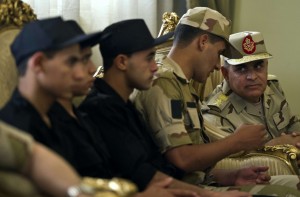 Egyptian military chief of staff Sedky Sobhy (R) listens to a soldier who was one of seven policemen and soldiers seized in Sinai by kidnappers upon their arrival at Almaza military Airbase in Cairo on May 22, 2013 following their release. (AFP Photo)