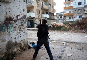 A Lebanese gunmen in the Sunni district of Bab al-Tabbaneh fires at a target following overnight clashes with the Alawite neighbourhood of Jabal Mohsen in the northern Lebanese port city of Tripoli, on May 25, 2013.  (AFP Photo)