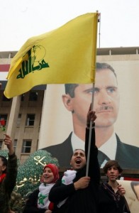 Syrian activists hold up a Lebanese Hezbollah flag during a pro-regime rally in Damascus in 2012 (AFP/File, Louai Beshara) 