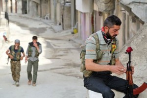 A rebel fighter of the Syrian Kurdish Popular Protection Units (YPG) has a flower in his gun in Aleppo on May 9, 2013 (AFP) 